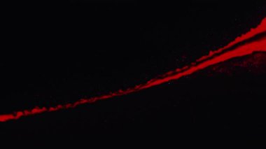 Mürekkep akışı. Parıltılı boya akışı. Koyu siyah sanat soyut arkaplan üzerinde kırmızı renk sıvısı sıçrama damlası harmanlama hareketi ve kopyalama alanı.