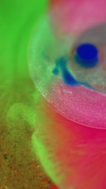 Mürekkep damlası. Yağ kabarcıkları. Odaklanmamış neon sarısı pembe renk gradyan simli doku şeffaf boya karışımı soyut sanat arkaplan.