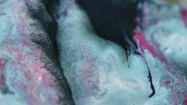 Boya dökülmüş. Parlak mürekkep akışı. Odaklanmamış mavi pembe renk ışıl ışıl metalik doku sıvı karışım akış hareketi soyut sanat arkaplanı.