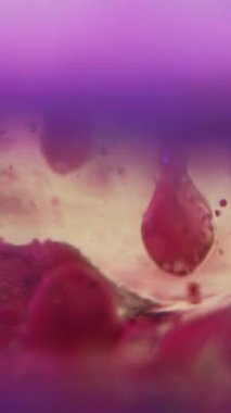 Dikey video. Renkli köpük köpükleri. Su damlasını boya. Odaklanmamış neon, mor, mavi, parıltılı, sıvı mürekkep, hareket sanatının soyut arkaplanı..