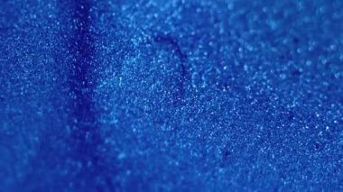 Boya damlası. Islak sim dokusu. Odaklanmamış mavi renk parıldayan parlak parçacıklar bokeh ışık mürekkep sıvısı parlatıcısı dalga hareketi soyut sanat arkaplanı.