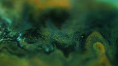 Bulanık mermer dokusu. Parıltılı boya akışı. Odaklanmamış yeşil altın sarısı siyah renk parıldayan mürekkep karışımı hareket soyut sanat arkaplanı.