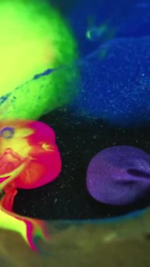 Renk parçacıkları su. Boya karışımı. Bulanık neon yeşil mor pembe simli desen mürekkep harmanlanmış koyu renk sanat soyut arka plan.
