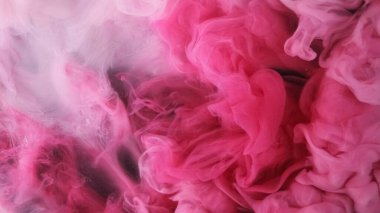 Su damlasını boya. Patlama bulutu. Odaklanmamış pembe renk toz parçacıkları siyah soyut sanat arka planında duman dalgası akışı.