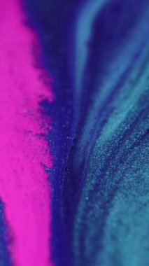 Dikey video. Parlak sıvı dokusu. Boya sıçraması. Odaklanmamış pembe renk parıldayan parçacıklar akrilik mürekkep karışımı akış hareketi soyut arkaplan.