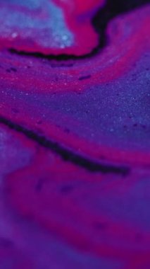Dikey video. Parıltılı boya döküldü. Mürekkep karışımı. Odaklanmamış neon mavisi mor renk parıldayan doku sıvı emülsiyon dalga hareketi soyut arkaplan dekoratif.