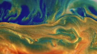 Köpüklü sıvı dalgası. Boya dökülmüş. Islak pul dokusu. Odaklanmamış altın sarısı mavi çivit rengi parlak parçacıklar karışık hareket soyut sanat arka planı.