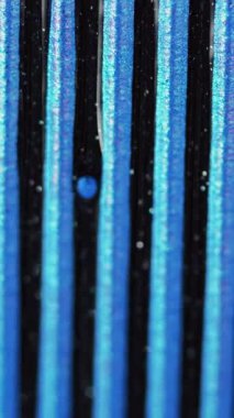 Dikey video. Parlak mürekkep arka planı. Boya karışımı. Işıl ışıl dökülüyor. Işıl ışıl siyah sıvı taneciklerin dokusu damla dalgası hipnotik soyut sanatta mavi boyaya yayılıyor..