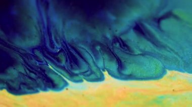 Parlak mürekkep sıçraması. Köpüklü sıvı dalgası. Odaklanmamış mavi indigo yeşil renk altın rengi parlak pullu partiküller sıvı boya emülsiyon su akışı hareket soyut sanat arka planı.