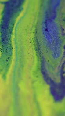 Dikey video. Boya dökülmüş. Parlak mürekkep akışı. Odaklanmamış yeşil mavi renk ışıl ışıl desen sıvı sıçrama dalgası hareketli soyut arkaplan.