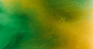 Parlak toz. Duman bulutu. Odaklanmamış simli soyut doku yeşil sarı renkli parıldayan parçacıklar buhar mürekkebi akış sanat arka planı.