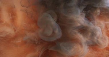 Parlak toz. Duman bulutu. Işıl ışıl koyu turuncu mürekkep. Hipnotik hareket soyut sanat arka plan sihirli atmosferik titreşen su sisi.