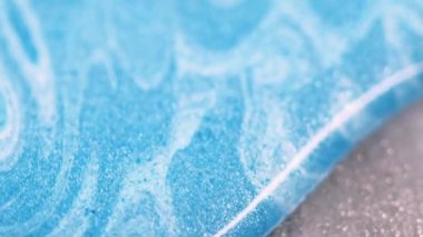 Boya damlası. Renkli mürekkep. Soyut mavi okyanus dalgası sıvı gök mavisi parlak parlak parlak parlak şeritler parıldayan desen metalik arka plan bokeh bulanıklığı.