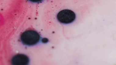 Parıltılı lekeler. Yağ damlaları mürekkep. Odaklanmamış pembe, sarı, beyaz, simli, koyu renkli, köpüklü, nemli, dokuma hareketli, soyut sanat arkaplanı..