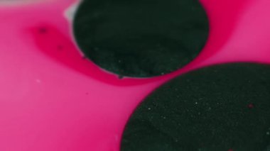 Parıltı damlası. Mürekkep akışı. Odaklanmamış mercan pembesi parlak leke emme parlak sıvı yağ baloncukları pürüzsüz doku soyut sanat arka planında yüzer.