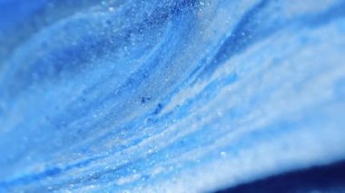 Islak sim dökülmüş. Işıldayan sıvı. Odaklanmamış mavi renk ışıl ışıl mermer desen boya karışımı dalga cazibesi soyut sanat arka planı.
