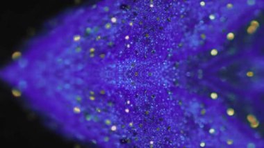 Islak sim sıçraması. Bulanık ışıltı sıvısı. Odaklanmamış mor altın rengi parlak desenli mürekkep akışı simetrik tasarımı koyu soyut sanat arka planında.