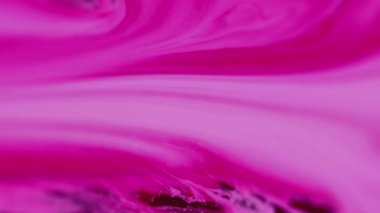 Sıvı mürekkep. Soyut arkaplan. Renkli dalgalar. Bulanık beyaz pembe boya akıntısı mor pigment karışımının yüzeyine yayılıyor..