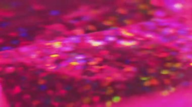 Göz kamaştırıcı bulanıklık. Bokeh ışıkları. Şeffaf döner kristal pembe yeşil mavi pullar yansıtan kirişler soyut eğimli arkaplan.