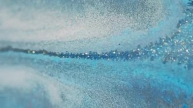 Islak sim dökülmüş. Mürekkep damlası. Bulanık mavi beyaz altın rengi parlak metalik parçacıklar dokusu boya sıvısı akışı soyut sanat arka planı.