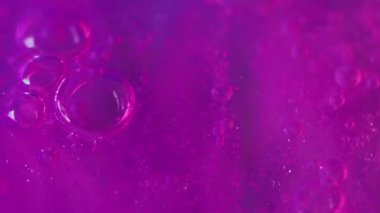 Disko boyası. Su kabarcıkları mürekkep. Odaklanmamış yanardöner mor renk floresan parıltı sıvısı köpük emülsiyon hareketi soyut sanat arka planı.