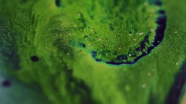 Parıltılı boya sıçraması. Parlak sıvı damlası. Bulanık yeşil renk parıldayan mürekkep karışımı bokeh ışık dokusu soyut sanat arkaplanı.