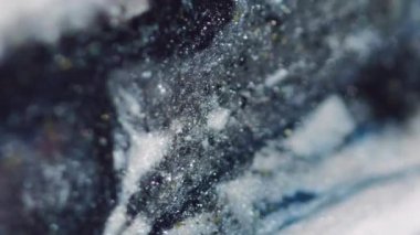 Parıltılı boya karışımı. Işıl ışıl tahıl dokusu. Buz gibi kar. Bulanık siyah mavi altın rengi parlak sıvı mürekkep akışı hareketi soyut sanat arkaplanı.