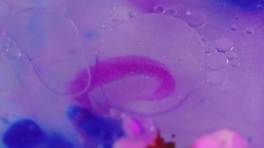 Neon boya. Uçan çiçekler. Parıldayan mürekkep. Söndürülmüş pembe mavi renk yarı şeffaf yağ damlaları parlatıcı jel yapraklar hareket soyut sanat arka planı.