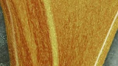 Parıldayan sıvı dökülmüş. Işıldayan doku. Bulanık altın rengi parlak desen sıvı mürekkep gümüş gri lüks soyut sanat arka planına damlıyor.