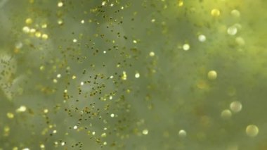 Bulanık parıltı dokusu. Bokeh ışığı üstüste biniyor. Sıralı parlatıcı. Odaklanmamış yeşil altın rengi parlak parçacıklar şeffaf jel akışkan hareket soyut sanat arka planı.