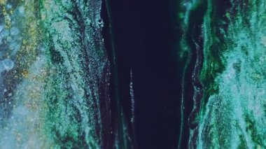 Işıldayan sıvı dökülmesi. Mürekkep damlası. Odaklanmamış mavi altın rengi parlak partiküller doku boya soyut sanat arkaplanı.