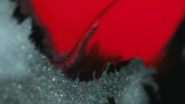 Boya dökülmüş. Parıldayan sıvı akışı. Odaklanmamış kırmızı gümüş rengi parlak parlak desen mürekkebi emülsiyon dalgası bokeh ışık soyut sanat arka planı.