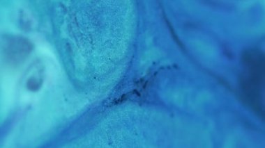 Islak sim dokusu. Mürekkep sıçraması. Bulanık neon mavisi mor parlak parlak boya sıvı parlatıcı dalga yayılması büyüleyici sanat soyut arkaplan.