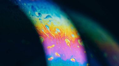 Bulanık psikedelik sıvı. Boya karışımı. Odaklanmamış turuncu mavi renk spektrumu. Yağlı boya damlacıkları koyu siyah soyut sanat arka planında akıyor..