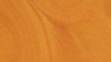 Işıldayan sıvı dökülmüş. Parlak boya dokusu. Bulanık turuncu altın rengi metalik parlak kum tanecikleri akrilik sıvı pigment mürekkep akış hareketi soyut sanat arka planı.