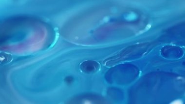 Yağ kabarcıkları. Köpüklü sıvı. Odaklanmamış mavi beyaz renk şeffaf yuvarlak damlacıklar yüzen jel dokusu boya su akışı hareketli soyut sanat arka planı.