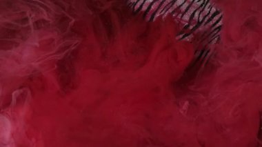 Mürekkep damlası. Buhar bulutu. Odaklanmamış kırmızı renk su altı tozu bulutu girdap dalgası parlak zebra desenli soyut sanat arkaplanı hareketini gösteriyor.