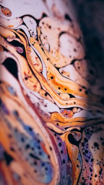 Psikedelik boya. Benzin yağı. Odaklanmamış pembe turuncu renkli gökkuşağı eğrisi koyu siyah soyut sanat arka planında akrilik kaygan.