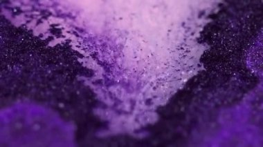Işıldayan sıvı dökülmesi. Islak sim dokusu. Odaklanmamış mor renkli parlak kum tanecikleri jel boyası karışım mürekkep akışı hareketi soyut sanat arka planı.