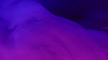 Floresan dumanı. Mürekkep damlası. Bulanık pembe mavi renk gradyan parlak duman bulutu koyu soyut sanat arka planında süzülüyor.