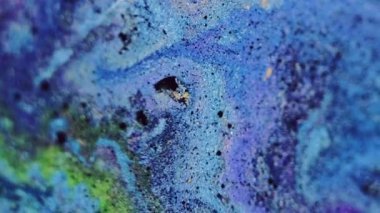 Parlak arka plan. Boya dökülüyor. Fantezi sıvısı. Yeşil, mor, parıldayan parçacıklar. Islak, soyut pigment. Hipnotik sızıntı yayılıyor..