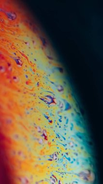 Boyalı spektrum. Yağ sıvısı. Odaklanmamış turuncu mavi gökkuşağı renk baloncukları koyu siyah soyut sanat arka planında doku dalgası.