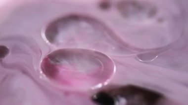 Yağ kabarcıkları. Köpüklü sıvı. Odaksız pembe renk şeffaf yuvarlak damlacıklar yüzen jel dokusu boya su akışı hareketli soyut sanat arka planı.