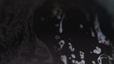 Sabun köpüğü. Köpüklü su. Odaklanmamış mavi yağ dokusu emülsiyon damlacıkları koyu siyah soyut sanat arka planında yüzer..