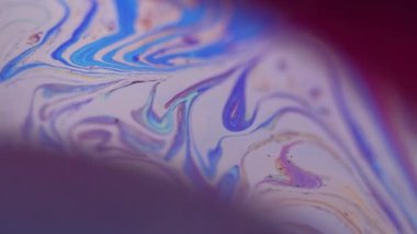 Köpük sıvısı karışımı. Boya akışı. Karanlık soyut sanat arka planında odaksız mor renkli sıvı akrilik emülsiyon dalgası hareketi.