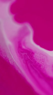 Dikey video. Mürekkep damlası. Sıvı dökülmesi. Odaklanmamış pembe beyaz pigment sıvı boya damlaları hareket yaratıcı sanat soyut arka plan yayıyor.