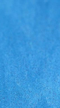 Dikey video. Parıldayan dalga. Renkli tahıl. Mavi soyut okyanus sanatı. Parlak parıltılar. Odaklanmış doku..