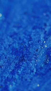 Dikey video. Parıldayan sıvı dökülmüş. Parlak boya taşması. Bulanık mavi siyah renkli parlak desenli ıslak mürekkep akışı soyut sanat arka planı.