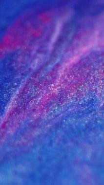 Dikey video. Boya dökülmüş. Parıltı dalgası. Odaklanmamış mavi pembe renk parıldayan desen mürekkep karışımı akışkan hareket soyut sanat arkaplanı.