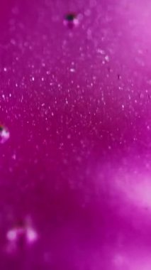 Dikey video. Işıldayan jel. Yağ kabarcıkları. Odaklanmamış neon pembe şeffaf parlak madde dökülmesi sanatın soyut arka planını yayıyor.